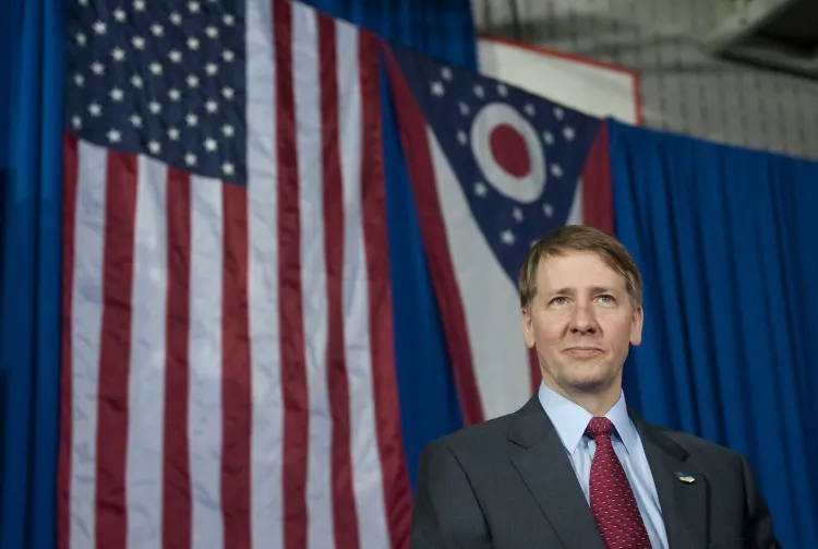 In this file photo, Richard Cordray, incoming head of the Consumer Financial Protection Bureau, stands offstage after President Barack Obama spoke in Shaker Heights, Ohio on Jan. 4. (Saul Loeb/AFP/Getty Images)