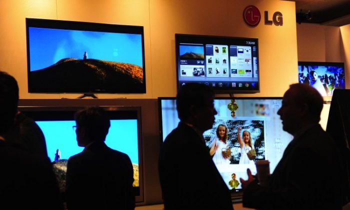People mingle in front of a display of LG Electronics televisions during the annual Consumer Electronics Show on Jan 9, 2012, in Las Vegas, Nev. The Environmental Protection Agency’s (EPA) new cable box energy standards, effective Jan. 1, 2013, aims to curb energy use. (Frederic J. Brown/AFP/Getty Images)