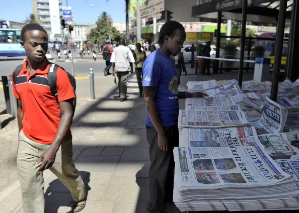 A man walks past a news stand displaying the day's papers carrying in the headlines photos of four Kenyans to face charges of crimes against humanity before the International Criminal Court, in the Kenyan capital Nairobi on January 24 2012. (Tony Karumba/AFP/Getty Images)