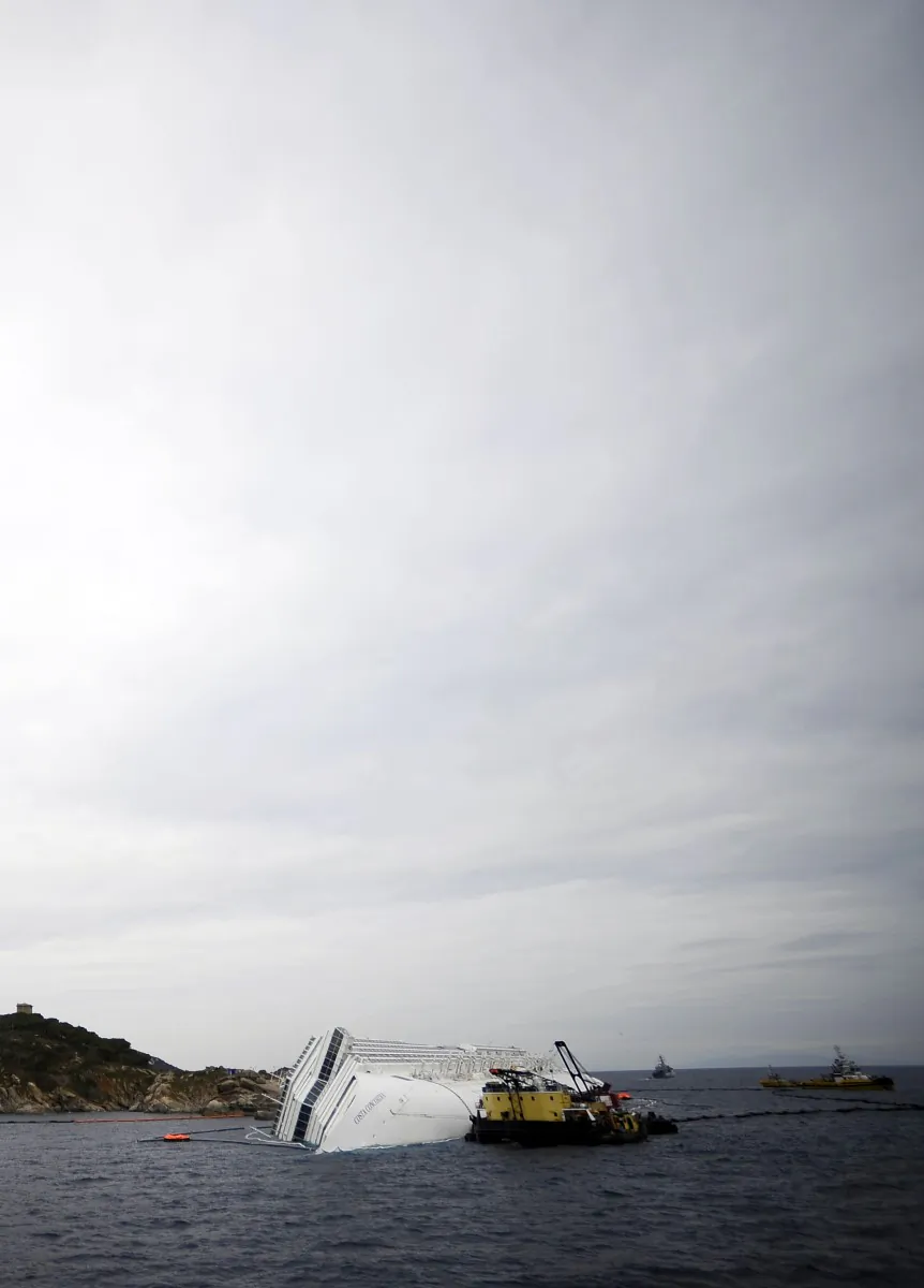 Technicians work near the cruise liner Costa Concordia liying aground in front of the Isola del Giglio (Giglio island) on January 27, 2012. (Filippo Monteforte/AFP/Getty Images)