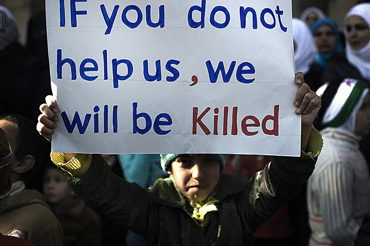 A young boy holds up a sign during an anti-regime demonstration in the Syrian village of al-Qsair, 25 km southwest of the flashpoint city Homs, on February 3, 2012. At least 107 were killed across Homs on Feb. 9, the Local Coordination Committees (LCC) said. (Alessio Romenzi/AFP/Getty Images)