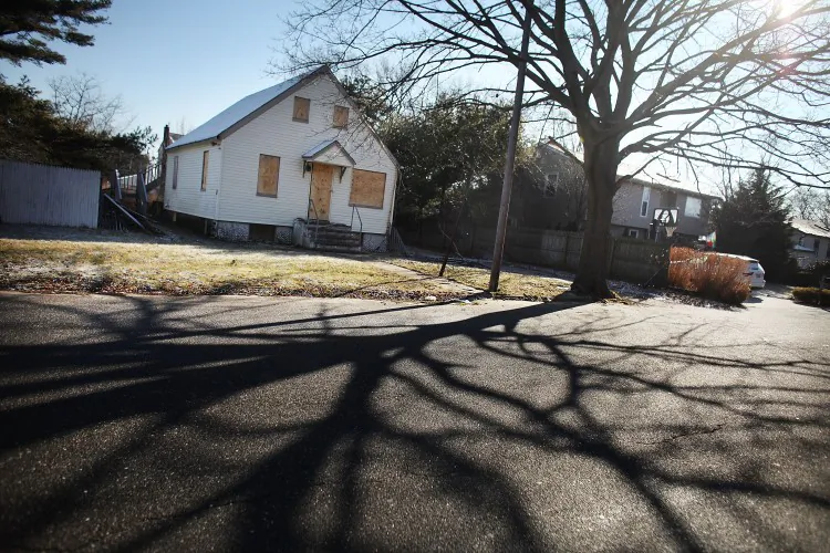 A foreclosed home stands boarded up in Islip, N.Y., in this file photo. Ten banks were part of a civil settlement with the Federal Reserve Board and the Office of the Comptroller of the Currency. They agreed to pay 3.8 million borrowers $3.3 billion in cash and $5.2 billion in other assistance, such as loan modifications. (Spencer Platt/Getty Images)
