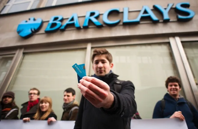 Barclays customer George Gabriel holds the pieces of his cut-up bank card during a protest outside a branch of Barclays bank in central London on February 10, 2012. The protest was a part of the "Move Your Money" campaign, the stated aims of which are to try to create what they consider a better banking system through consumer power. Barclays announced a 16-percent drop in annual net profits to 3.0 billion British pounds on falling revenues at its investment arm, and also announced a one-quarter cut in its bonus pool on February 10. (Leon Neal/AFP/Getty Images)
