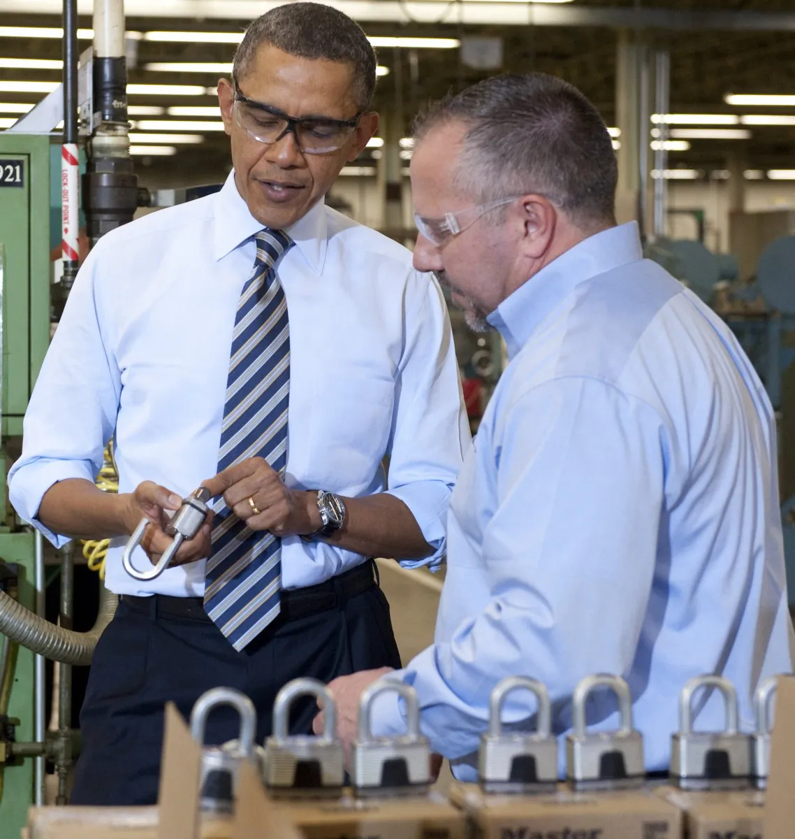 President Barack Obama (L) examines a lock at Master Lock, alongside Bob Rice (R), Master Lock Senior Vice President, in Milwaukee, Wis., on Feb. 15. (SAUL LOEB/AFP/Getty Images)
