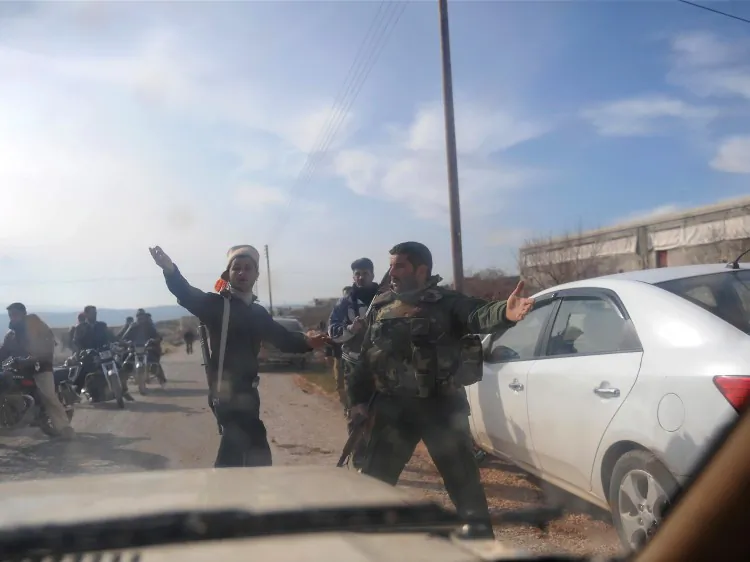 Seen through the windshield of a car, members of the Free Syrian Army (FSA) take position in Idlib in northwestern Syria on Feb. 22, 2012. (BulentKilic/AFP/Getty Images)