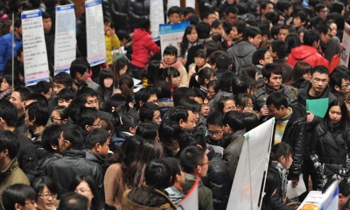 Thousands of job seekers flock to an employment fair in Hefei, east China's Anhui Province on Feb. 25. A decline in the housing market will create unemployment and depress other economic sectors that hinge on real estate. (STR/AFP/Getty Images)