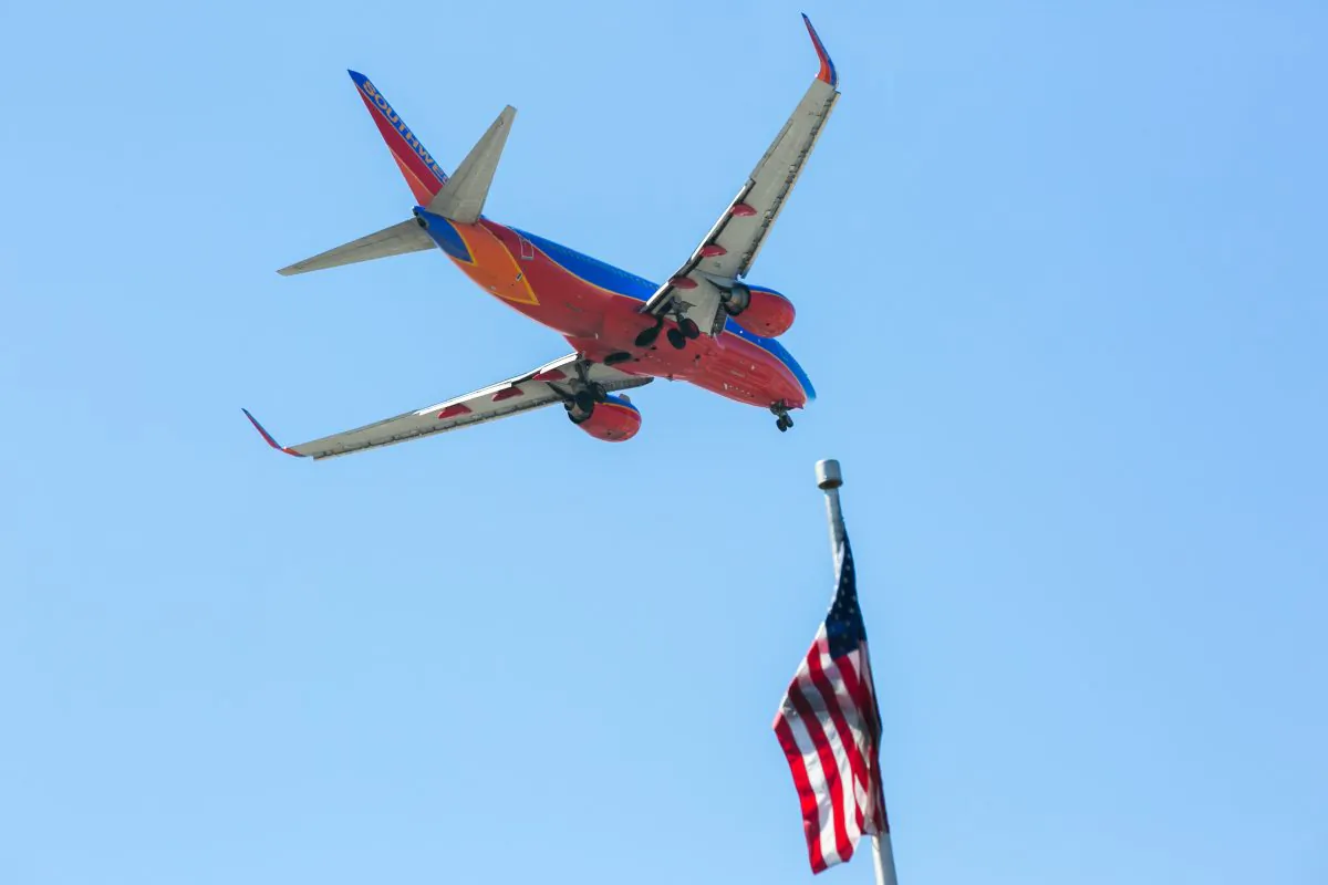 A Southwest Airlines jet flies over an American Flag before landing at the JFK airport in New York City on April 24, 2015. (Benjamin Chasteen/Epoch Times)