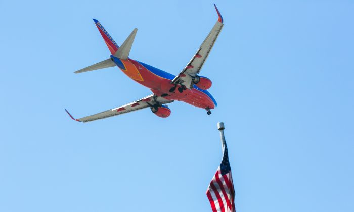 A Southwest Airlines jet flies over an American Flag before landing at the JFK airport in New York City on April 24, 2015. (Benjamin Chasteen/Epoch Times)
