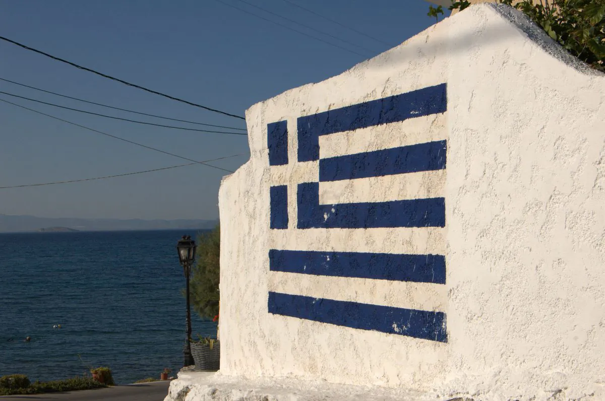 Hitting the wall. Greece’s future is still in the balance. The Greek flag in a wall in Attica, Greece, on June 25, 2008. (Erik Eskedal/CC BY 2.0/Flickr)