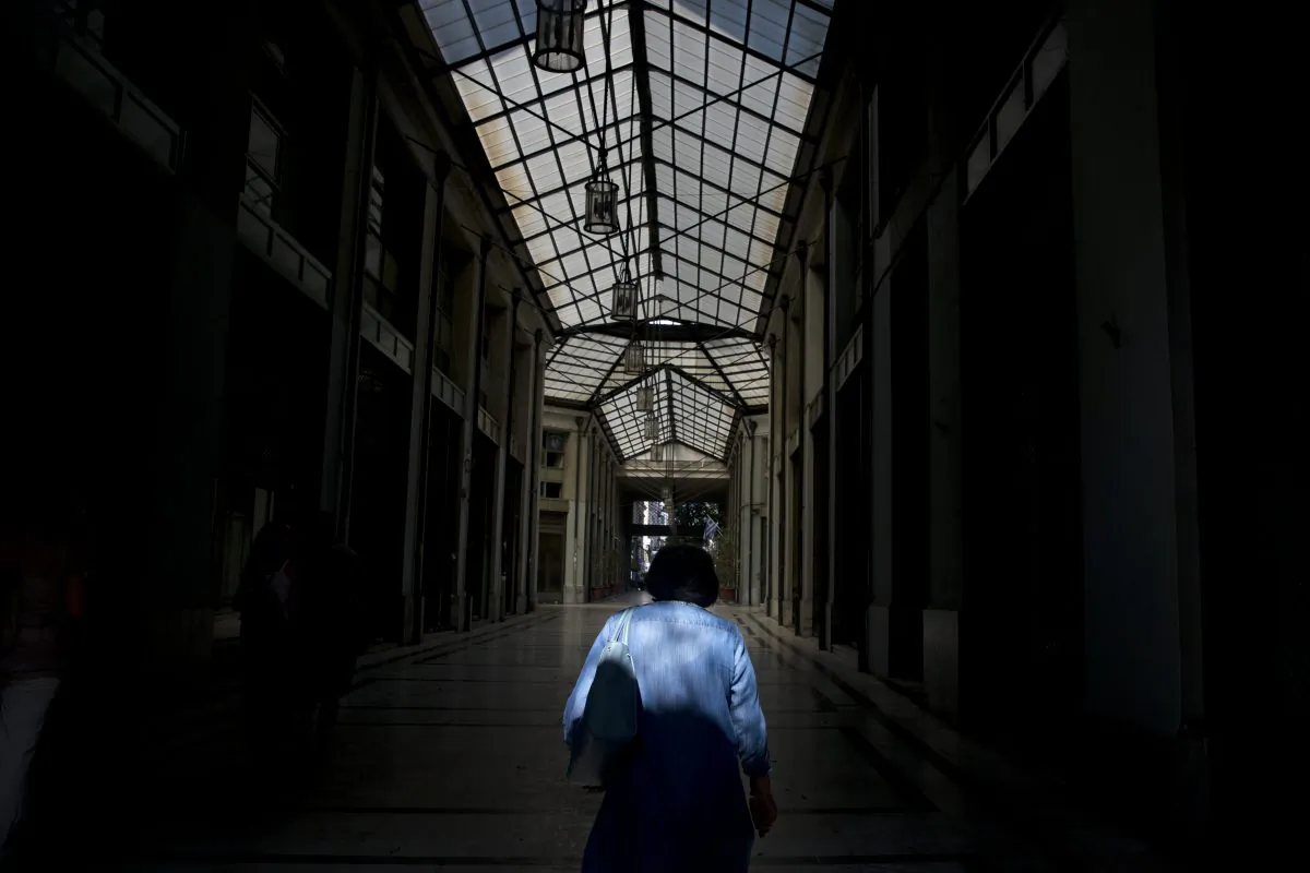 A man passes through an arcade with shuttered shops in central Athens, Tuesday, July 14, 2015. ((AP Photo/Petros Giannakouris)