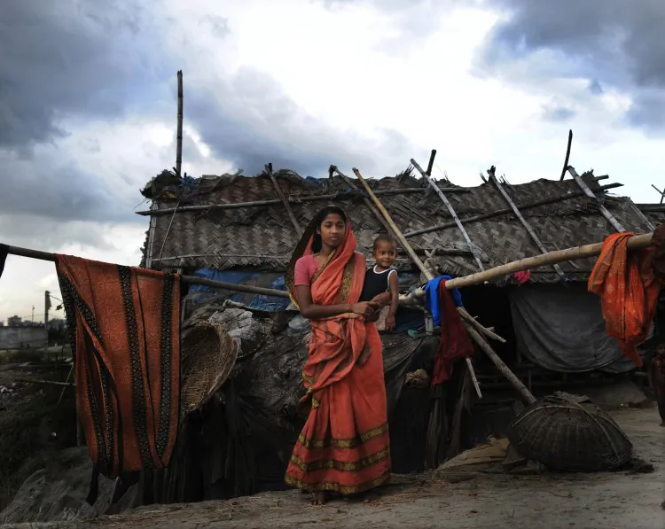 Suriya Begum, a slum dweller in the Bangladeshi capital Dhaka, holds her baby (file photo). A new report states that the least developed countries suffered a 7 percent decline in GDP due to climate change in 2010. (Munir Uz Zaman/AFP/Getty Images)