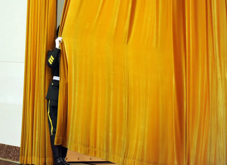 A Chinese guard shuts a drape prior to a welcoming ceremony at the Great Hall of the People in Beijing, April 9, 2012. China reassigned a large number of high-ranking military officers and the process is not transparent. (Liu Jin/AFP/Getty Images)