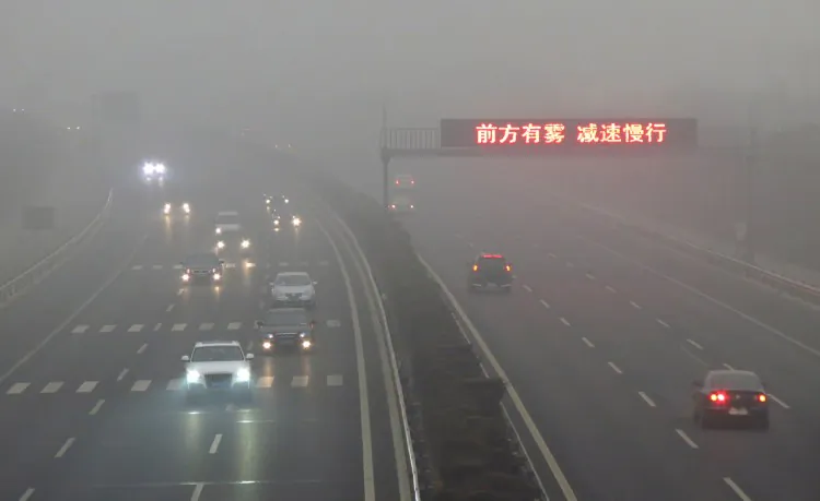 Vehicles make their way along a highway as fog covers most of Beijing on March 17, 2012. More than 400 flights to and from Beijing airport, including around 35 international services, were cancelled or delayed. (STR/AFP/Getty Images)