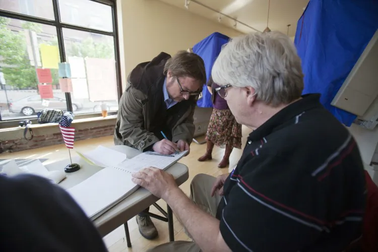 A man signs in to vote during the Republican primary election on April 24, 2012, in Philadelphia, Pa. Photo ID requirements in Pennsylvania, Tennessee, and Kansas are likely to be in effect in November, according to News21. (Jessica Kourkounis/Getty Images)
