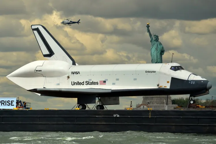 The space shuttle Enterprise is towed by barge past the Statue of Liberty June 6, 2012 on its way to the Intrepid Sea, Air and Space Museum where it will be permanently displayed. (Stand Honda/AFP/Getty Images)