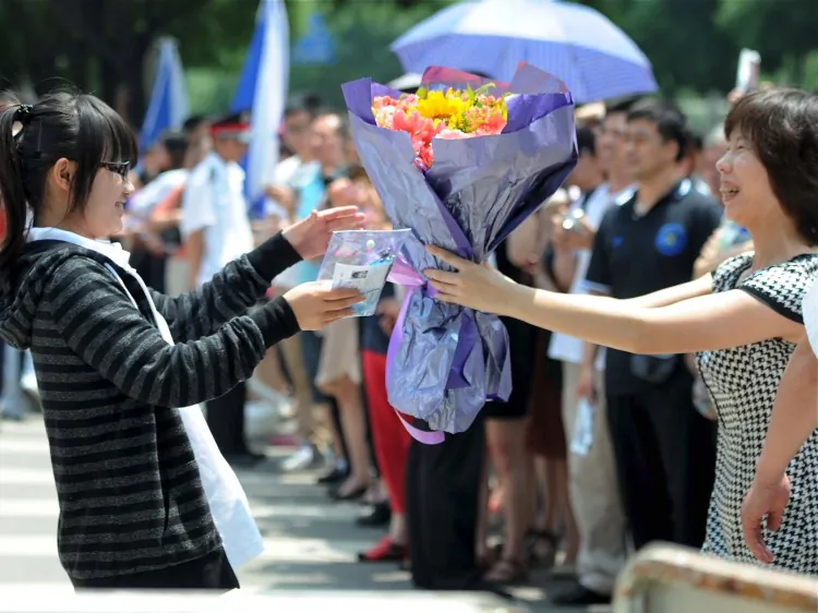 A mother greets her daughter who finished the first day of difficult college entrance exams, or "gaokao," in Beijing. Current policies make it more difficult for students born in rural provinces to enter prominent universities, even if their parents work and live in an urban area. (STR/AFP/GettyImages)
