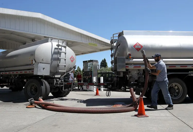 A truck driver delivers fuel to a gas station. A Simon Fraser University research team is developing technology that will reduce fuel consumption and emissions in service vehicles and long-haul trucks. (Justin Sullivan/Getty Images)