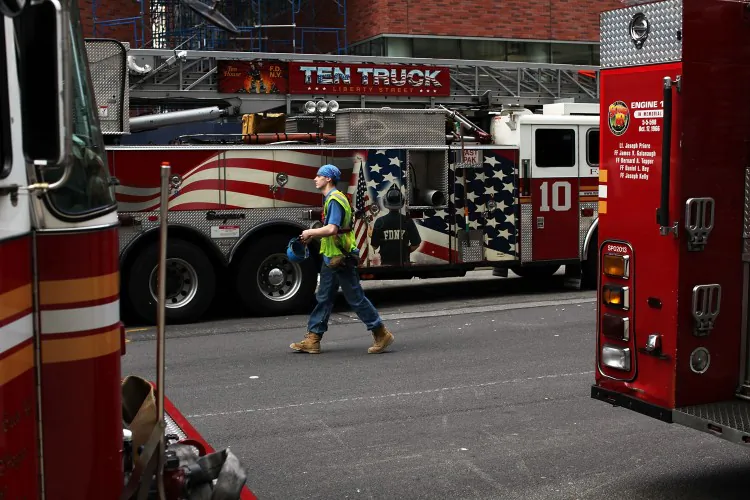 A Ground Zero construction worker walks by fire trucks on June 14, in New York City. (Spencer Platt/Getty Images)
