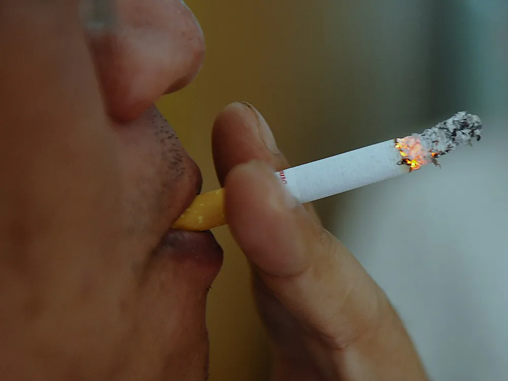 A man smokes a cigarette at a coffee shop. (HOANG DINH NAM/AFP/GettyImages)