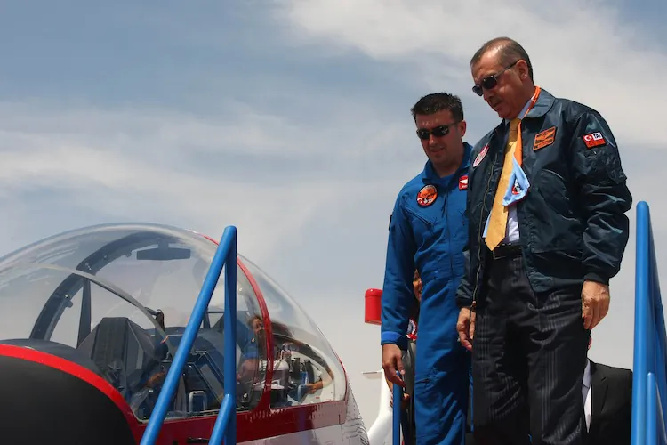 Turkish Prime Minister Recep Tayyip Erdogan (L) gets into the cockpit of a Hurkus (Freebird) outside Ankara on June 27, 2012. (Adem Atan/AFP/GettyImages)