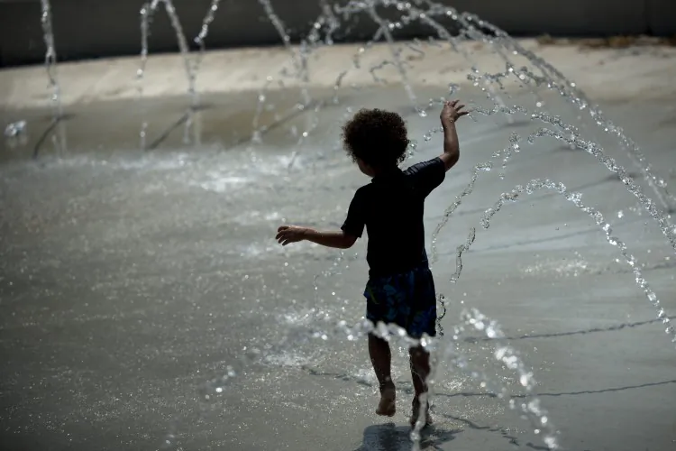 A boy plays in a water fountain at Wheatley Recreation Center on July 1 in Washington, D.C. Temperatures reached the 100-degree range in many areas, prompting the National Weather Service to warn of the prospect of severe thunderstorms. (Brendan Smialowski/AFP/GettyImages)