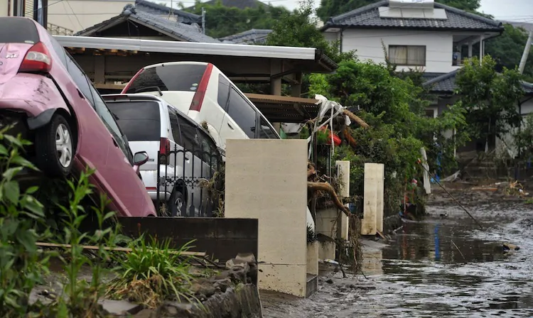 Vehicles are piled-up in a residential area covered in mud after heavy rains fell at Kumamoto city in Japan's southern island of Kyushu on July 12, 2012. (Jiji Press/AFP/GettyImages)