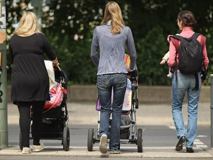 Women with young babies walk towards a park in Germany. Once thought of as something only women in developing countries used, slings are now gaining popularity in Western countries too. (Sean Gallup/Getty Images)