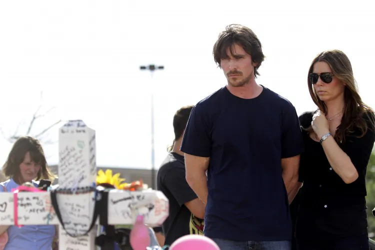 Actor Christian Bale and wife Sibi Blazic visit the memorial across the street from the Century 16 movie theater July 24 in Aurora, Colo. The memorial was created for the victims of the mass shooting that occured at the theater last Friday. James Holmes, 24, is accused of killing 12 people and injuring 58 at a screening of the new Batman film. (Joshua Lott/Getty Images)