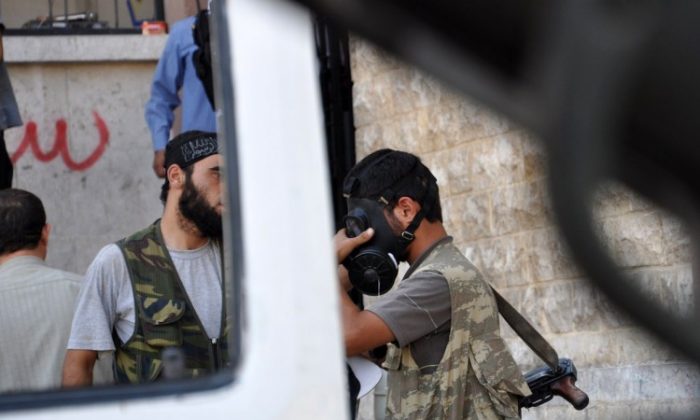 A Syrian opposition fighter tries a gasmask in the northern city of Aleppo on July 25, 2012. (Pierre Torres/AFP/GettyImages)