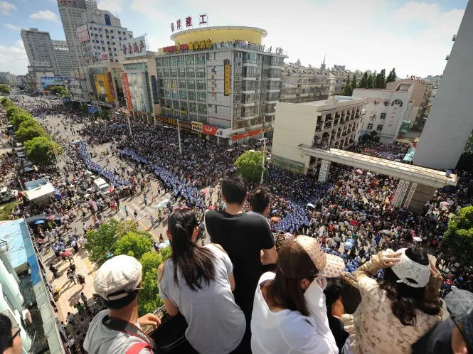 Locals watch protests in Qidong, a city near Shanghai, from a nearby roof on July 28. Activists have now called for protests in Shanghai, and police are arresting people and putting them under surveillance. (Peter Parks/AFP/Getty Images)