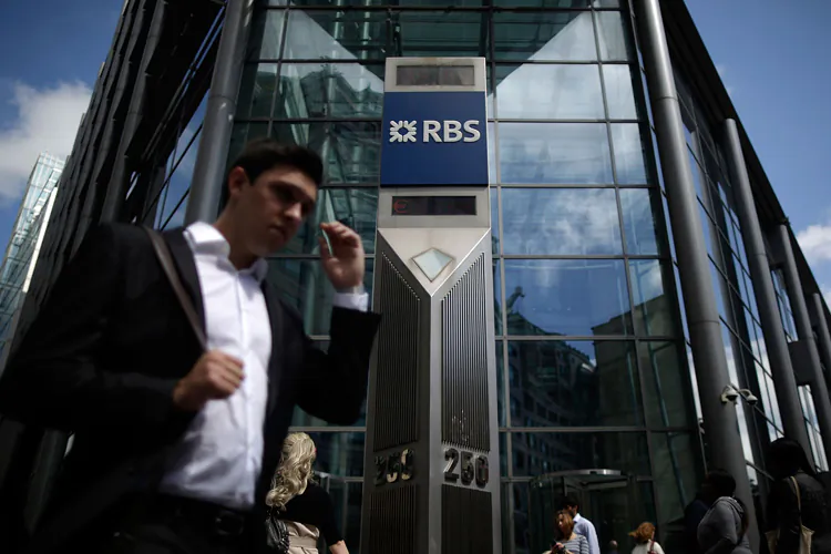 Workers pass the Royal Bank of Scotland (RBS) building on Bishopsgate on Aug. 3, 2012, in London. The bank reached a $612 million settlement on LIBOR-fixing allegations with U.S. and U.K. regulators. (Matthew Lloyd/Getty Images)