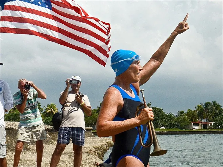 U.S. swimmer Diana Nyad (R) gestures and plays a bugle before her departure from the Ernest Hemingway Nautical Club in Havana on Aug. 18. Nyad, 62, is attempting to become the first person to swim across the waters between Cuba and Florida without a shark cage. (Adalberto Roque/AFP/Getty Images)