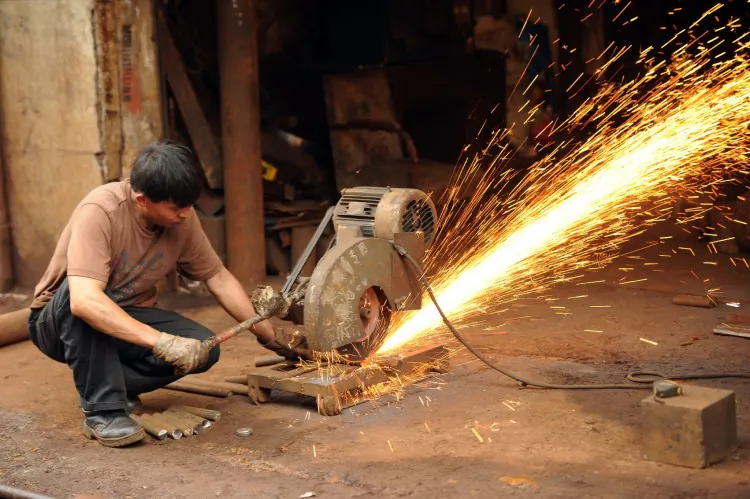 A machinist uses an industrial saw to cut steel at a workshop Shanghai last month. (Peter Parks/AFP/GettyImages)