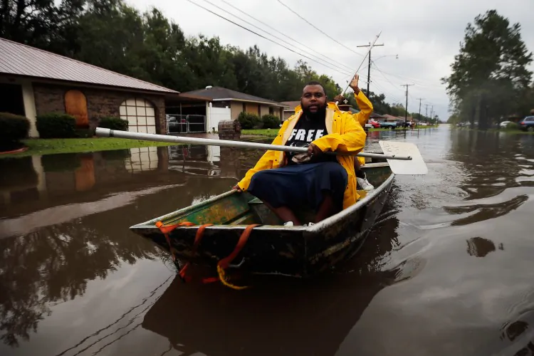 Two men paddle a boat with street signs in flood waters from Hurricane Isaac on August 30, 2012 in Reserve, Louisiana. Over the last decade, natural disasters have caused $500 billion worth of damage. (Chris Graythen/Getty Images)