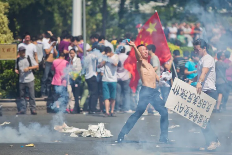 Anti-Japanese protester throws a gas cannister as they demonstrate over the disputed Senkaku Islands, on Sept. 16, 2012 in Shenzhen, China. Protests have taken place across China in a dispute that is becoming increasingly worrying for regional stability.  (Lam Yik Fei/Getty Images)