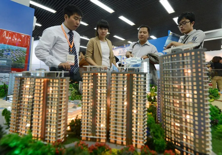 People view a model of a property development being sold at the Beijing Property and Investment Show on Sept. 20, 2012. Soaring housing prices have helped increase income inequality in China, as the rich have gotten richer while the poor have found housing increasingly difficult to afford. (MARK RALSTON/AFP/GettyImages)