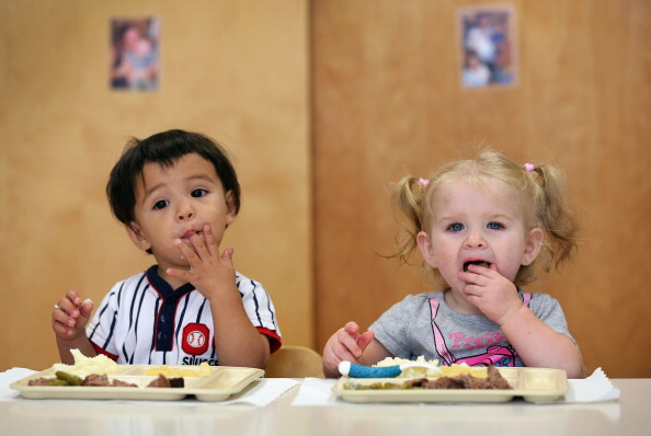 In this file photo, two young children eat at a Head Start center in New York. New changes in the federal program require some Head Start centers to compete in order to keep their grants. (John Moore/Getty Images)