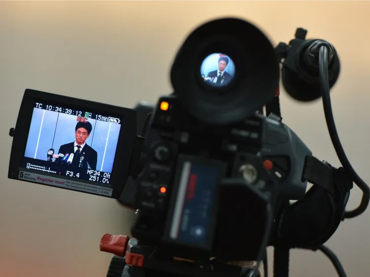 A video camera shows Chengdu People's Intermediate court spokesman Yang Yuquan delivering the verdict of the ex-police chief Wang Lijun to the press in Chengdu, on Sept. 24, 2012. Although Hu, Wen, and Xi have gradually gained the upper hand, they have chosen not to hold Jiang’s faction accountable for organ harvesting. (Mark Ralston/AFP/Getty Images)