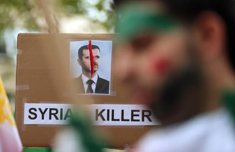 A sign denouncing Bashar Assad, President of Syria, is displayed at a rally of groups opposing Iranian President Ahmadinejadâs speech at the United Nations General Assembly on September 26, 2012 in New York City. (Mario Tama/Getty Images)