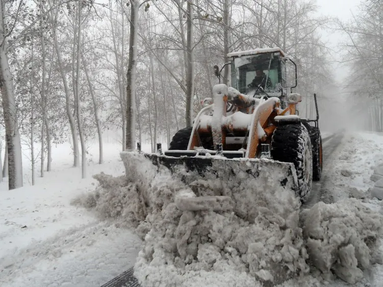 A worker uses a bulldozer to clear a snow-covered street after heavy snow-fall in the outskirts of Beijing on Nov. 4, 2012. Over the past few days, more blizzards have hit much of northern China. (STR/AFP/Getty Images)