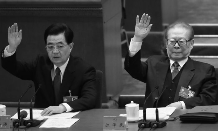 Former Chinese Communist Party head Hu Jintao and former Party head Jiang Zemin raise their hands during the closing session of the 18th Party Congress on Nov. 14, 2012, in Beijing. Hu visited Yancheng City, Jiangsu to deal with a Falun Gong matter in December, according to a source. (Feng Li/Getty Images)