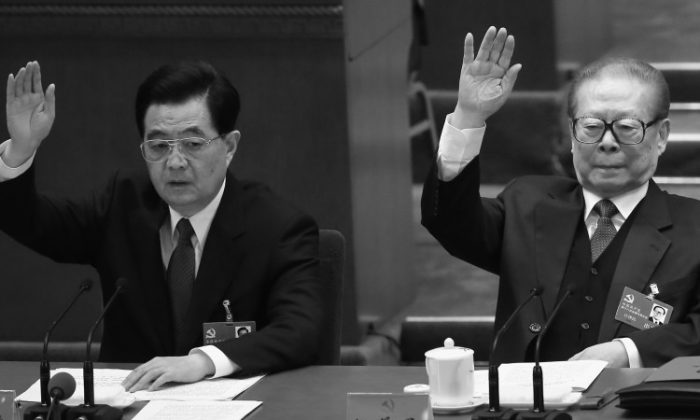 Outgoing Communist Party head Hu Jintao (L) and former Party head Jiang Zemin (R) raise their hands as they take a vote during the closing session of the 18th Party Congress on Nov. 14, 2012 in Beijing, China. New Party leaders were introduced the next day. (Feng Li/Getty Images)