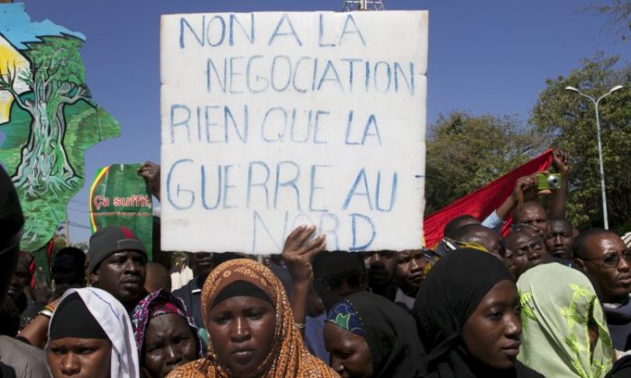 A man holds a banner that reads 'No to negotiation, only war in the north' as thousands of Malians gather in Mali's capital, Bamako, on Dec. 8, 2012. Malians are divided—some call for foreign military intervention to reclaim the north, controlled for eight months by Islamist armed groups, while some fear intervention could bring a new bout of tension and a new humanitarian crisis. (HABIBOU KOUYATE/AFP/Getty Images)