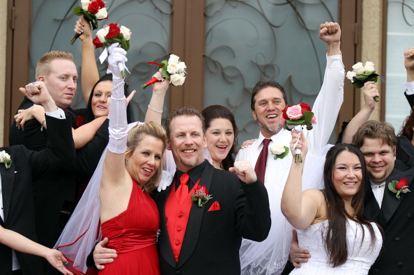 A dozen newlyweds pose for photos after participating in a mass wedding as part of a radio station contest at the Little Chapel of the Flowers on Dec. 12, 2012 in Las Vegas. (Isaac Brekken/Getty Images)