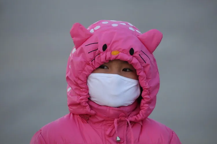 A girl wears a mask at the Tiananmen Square on Jan. 17, 2013 in Beijing to protect against air pollution. (Feng Li/Getty Images)