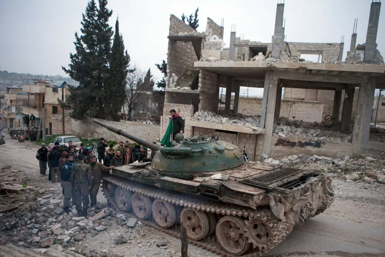Syrian rebels gather around a T-72 tank in the village of Kfarruma in the Syrian province of Idlib on Feb.10, 2013. (Daniel Leal-Olivias/AFP/Getty Images)