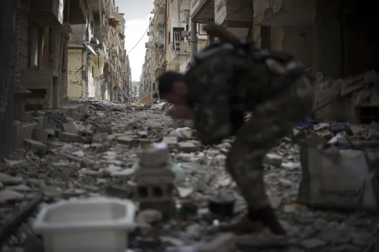 A Syrian opposition fighter rubs dust from his face in the Jabilleh neighbourhood of the eastern city of Deiz Ezzor, during clashes with regime forces as they try to retake the area on Feb. 16, 2013. (Zac Baillie/AFP/Getty Images)
