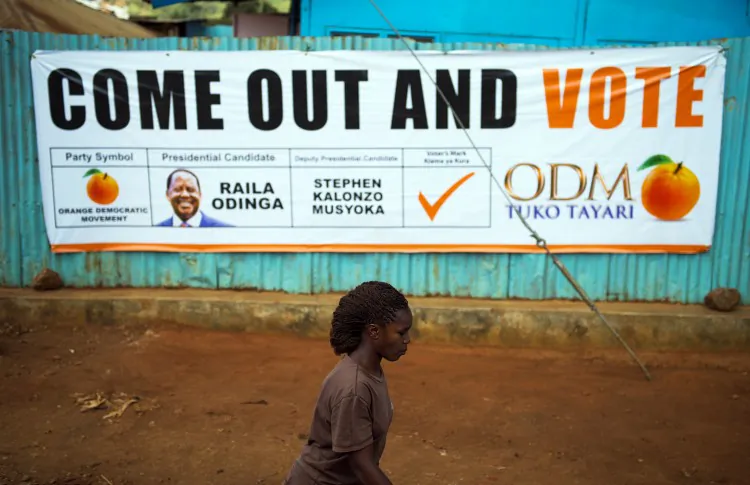 A man walks past a wall sprayed with graffiti reading 'We need peace in Kenya' in Nairobi's Kibera slum on Feb. 27, 2013. (Phil Moore/AFP/Getty Images)