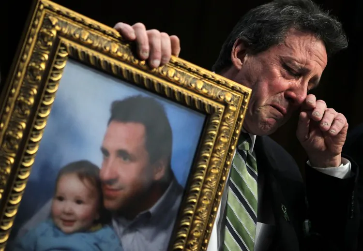 Neil Heslin, father of 6-year-old Sandy Hook Elementary School shooting victim Jesse Lewis, holds a picture of himself with 6-month-old Jesse as he testifies during a hearing before the Senate Judiciary Committee on Feb. 27, 2013, on Capitol Hill in Washington, D.C. (Alex Wong/Getty Images)