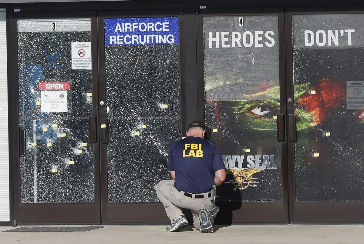 An FBI investigator investigates the scene of a shooting outside a military recruiting center on Friday, July 17, 2015, in Chattanooga, Tenn. (AP Photo/John Bazemore)